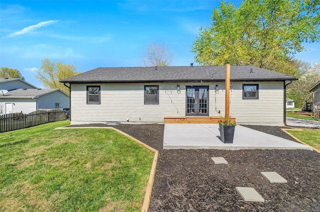 back of property with french doors, fence, a lawn, and a patio area