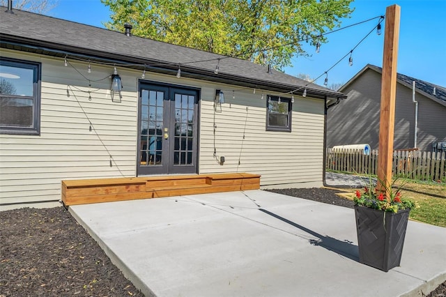 back of property featuring french doors, fence, a patio area, and roof with shingles