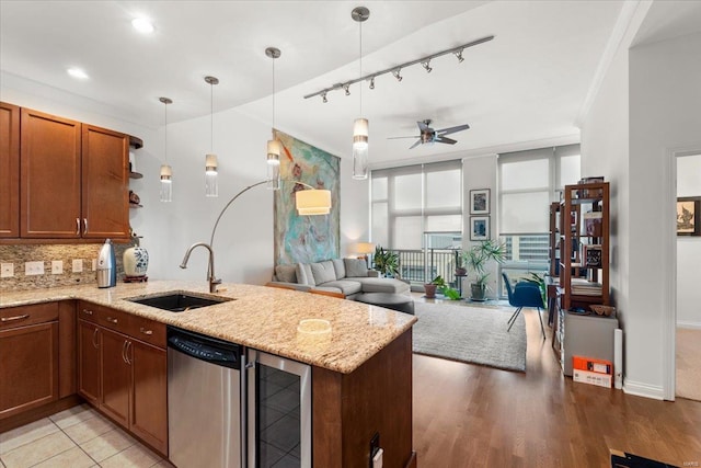 kitchen with a sink, a peninsula, wine cooler, ceiling fan, and open floor plan