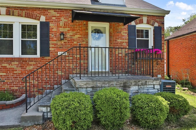property entrance featuring brick siding and cooling unit
