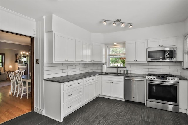 kitchen featuring a sink, white cabinetry, ornamental molding, and stainless steel appliances