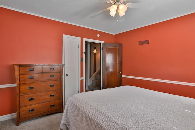 bedroom featuring crown molding, ceiling fan, carpet, baseboards, and visible vents