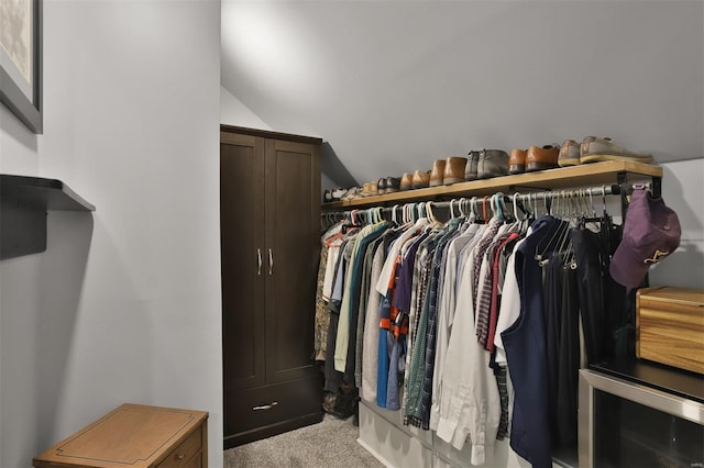 walk in closet with carpet floors and lofted ceiling