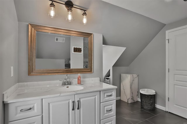 bathroom with baseboards, visible vents, lofted ceiling, and vanity