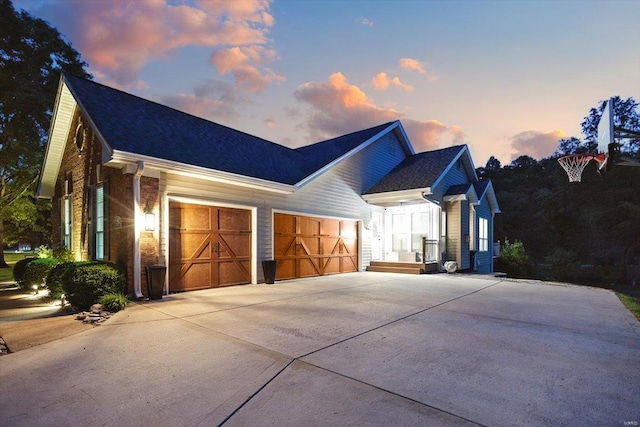 view of front facade featuring an attached garage, a shingled roof, and concrete driveway