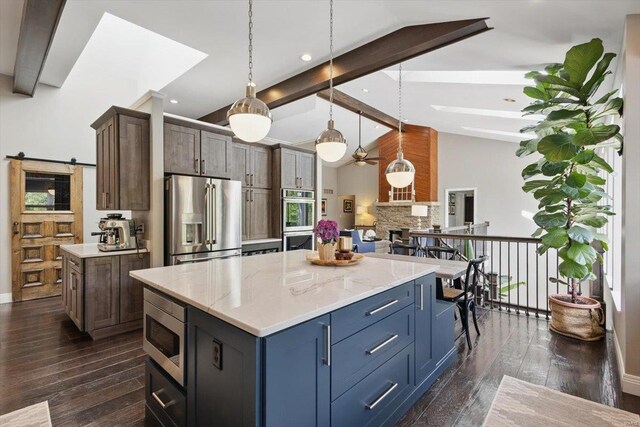 kitchen with dark wood-style flooring, stainless steel appliances, vaulted ceiling with beams, and a center island