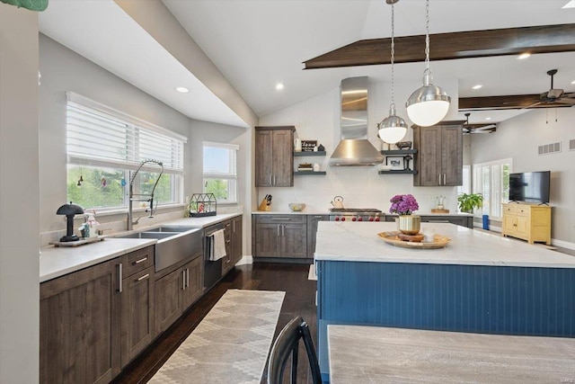 kitchen featuring dark wood-style flooring, visible vents, a sink, dishwashing machine, and wall chimney exhaust hood