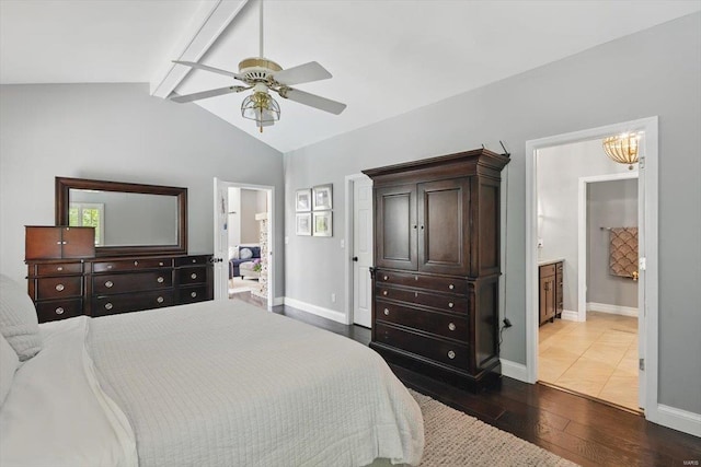 bedroom featuring dark wood-style flooring, baseboards, lofted ceiling with beams, ceiling fan with notable chandelier, and ensuite bath