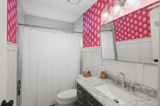full bath with vanity, a wainscoted wall, toilet, and wallpapered walls