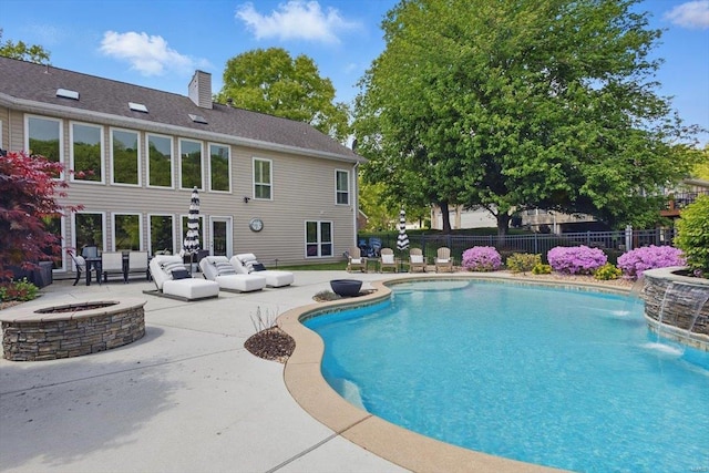 view of pool featuring fence, an outdoor living space with a fire pit, a patio area, and a fenced in pool