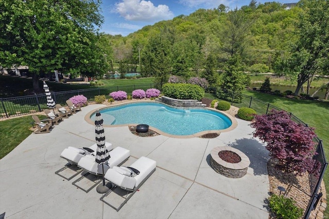 view of pool with a lawn, a patio area, a fenced in pool, a fenced backyard, and an outdoor fire pit