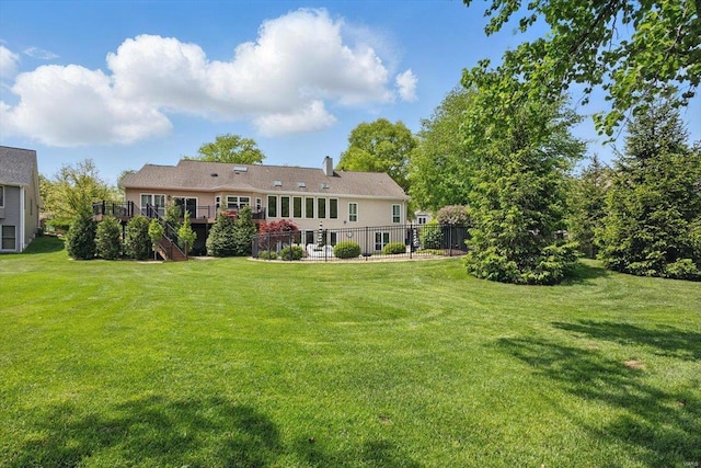 back of property with a lawn, stairs, and a deck