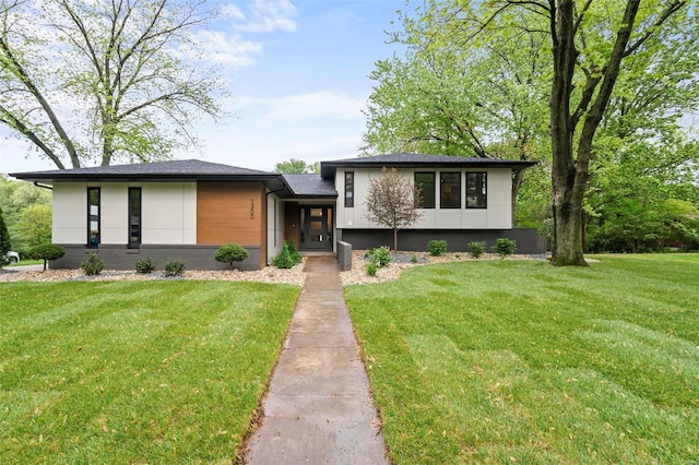 view of front facade with brick siding and a front lawn
