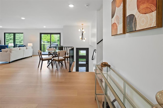 entrance foyer featuring recessed lighting, a notable chandelier, stairway, and light wood-style floors