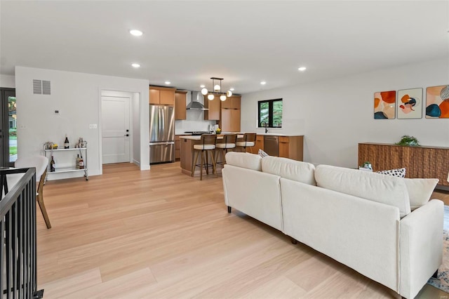living room with recessed lighting, visible vents, a chandelier, and light wood-style floors