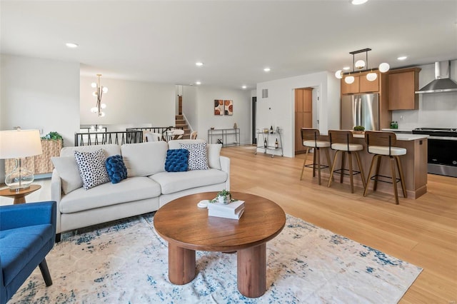 living area featuring recessed lighting, light wood finished floors, and a chandelier
