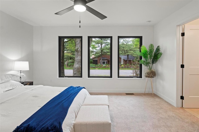 bedroom with a ceiling fan, baseboards, visible vents, and carpet