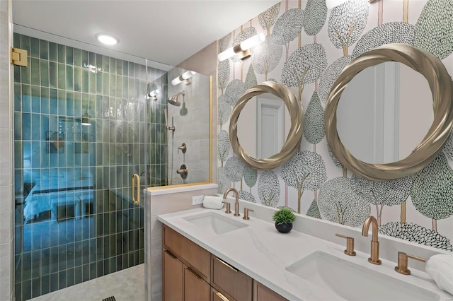 bathroom with double vanity, a sink, and a tile shower