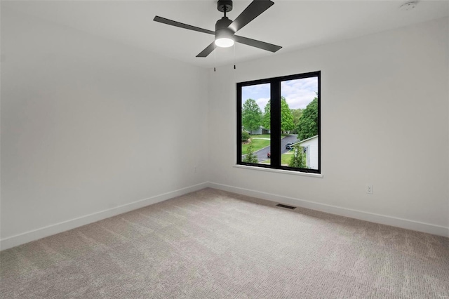 unfurnished room with baseboards, visible vents, and light carpet
