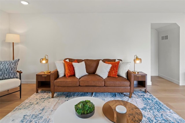 living room with visible vents, recessed lighting, baseboards, and wood finished floors