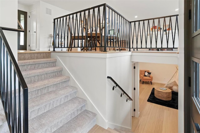 stairs featuring recessed lighting, baseboards, visible vents, and wood finished floors