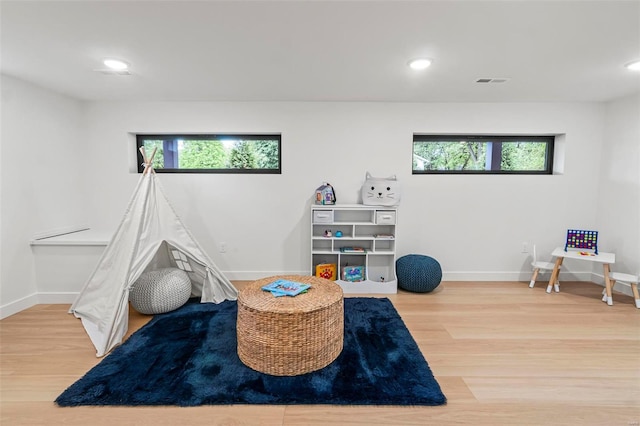 game room with a wealth of natural light, wood finished floors, and visible vents