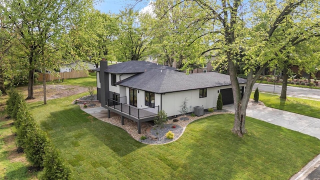 view of front facade with driveway, a chimney, roof with shingles, and a front lawn