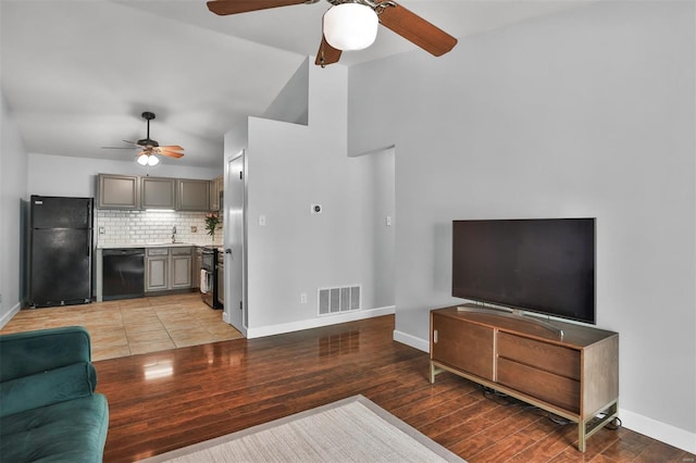 living area with a ceiling fan, baseboards, visible vents, and light wood-style flooring