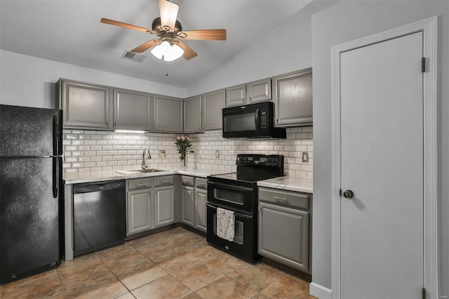 kitchen featuring a sink, gray cabinets, decorative backsplash, visible vents, and black appliances