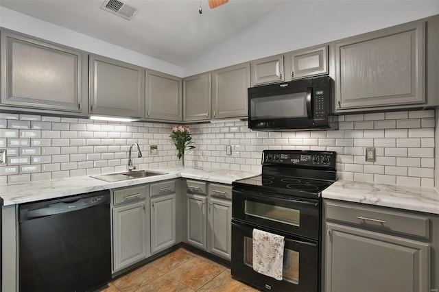 kitchen featuring gray cabinetry, black appliances, a sink, and visible vents