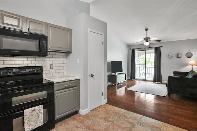 kitchen with open floor plan, gray cabinets, backsplash, and black appliances