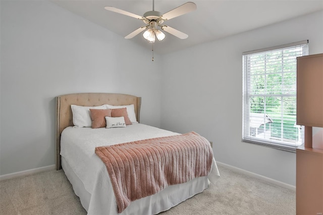 carpeted bedroom featuring baseboards and a ceiling fan