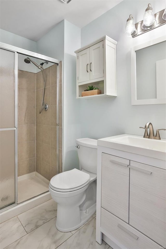 full bathroom with vanity, a shower stall, toilet, and marble finish floor