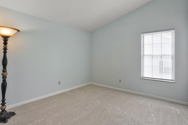 unfurnished room with baseboards, a wealth of natural light, and light carpet