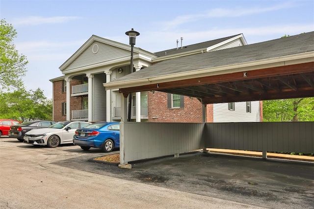 view of property featuring covered and uncovered parking