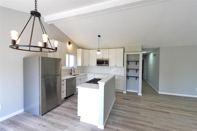 kitchen with a sink, stainless steel appliances, backsplash, light countertops, and white cabinets