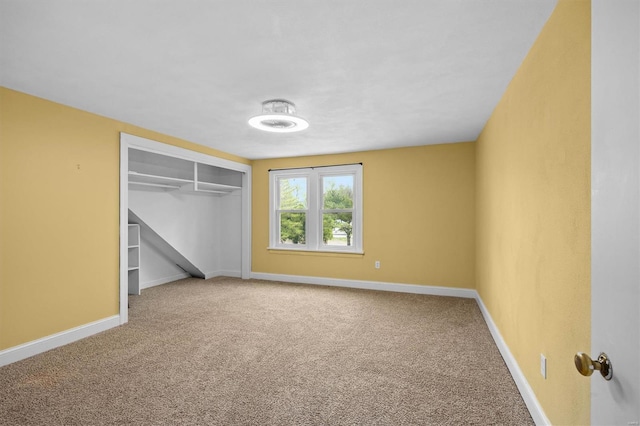 unfurnished bedroom featuring carpet flooring, baseboards, and a closet