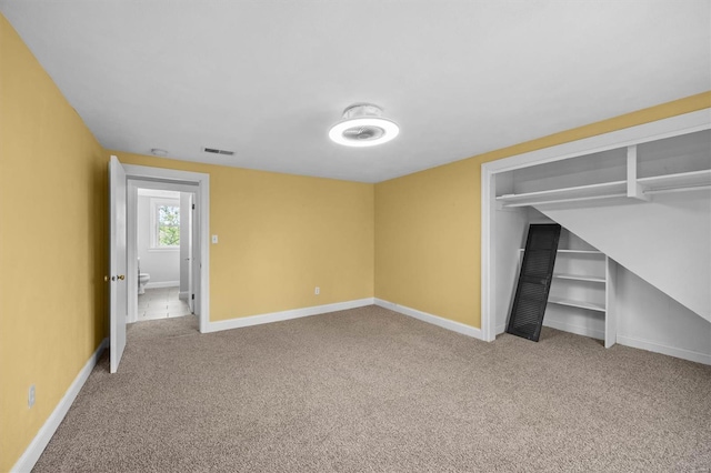 unfurnished bedroom featuring carpet floors, baseboards, visible vents, and a closet