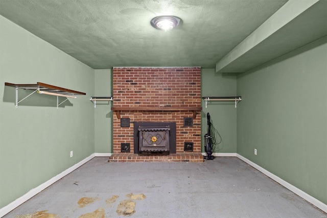 unfurnished living room featuring baseboards, a wood stove, and concrete floors