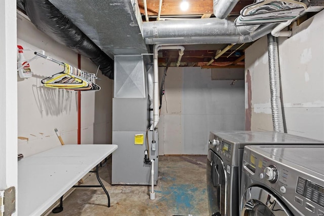 unfinished basement featuring heating unit and washing machine and clothes dryer