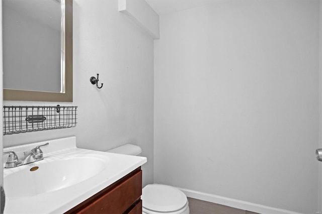 bathroom featuring vanity, baseboards, and toilet