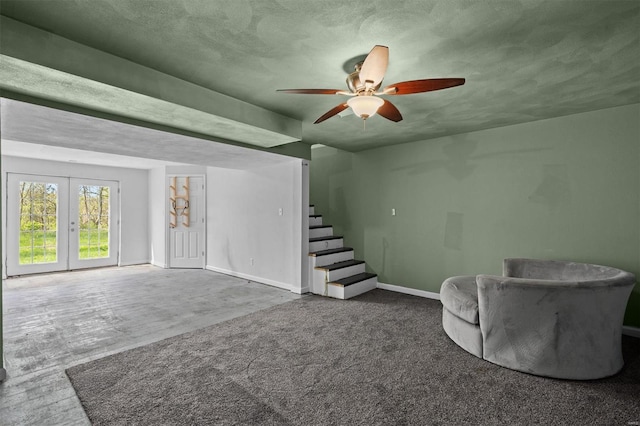 unfurnished living room with ceiling fan, french doors, a textured ceiling, stairway, and baseboards
