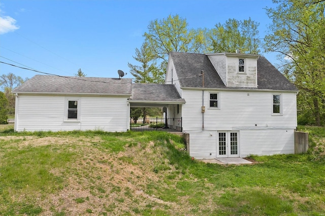 back of house with french doors, a lawn, and roof with shingles