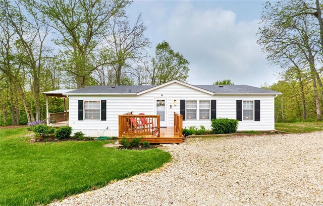 manufactured / mobile home featuring a wooden deck and a front lawn
