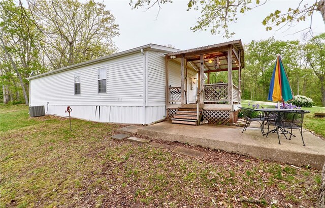 back of property featuring a patio, a wooden deck, and cooling unit