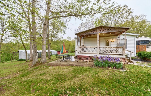 rear view of house with a patio and a yard