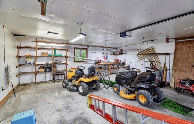 garage with a garage door opener and a workshop area