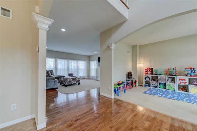 rec room featuring ornate columns, arched walkways, visible vents, and wood finished floors