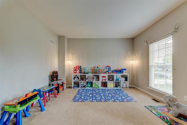 recreation room featuring carpet floors, plenty of natural light, and visible vents