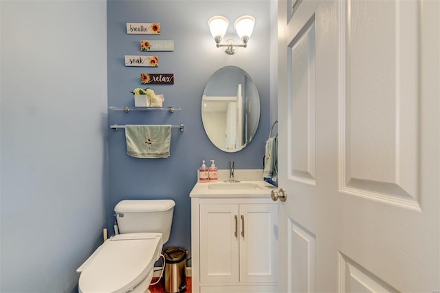 half bathroom featuring vanity and toilet